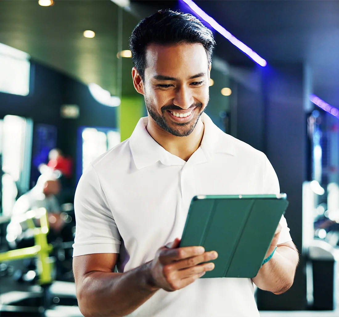 A facility staff member using My Maintenance on a tablet in a gym.